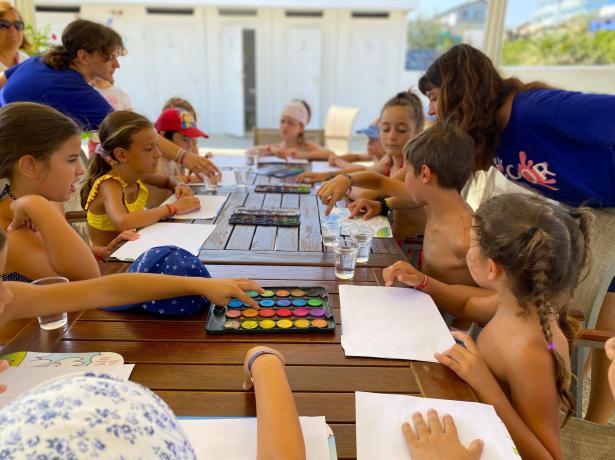 Children painting together in an outdoor art class.