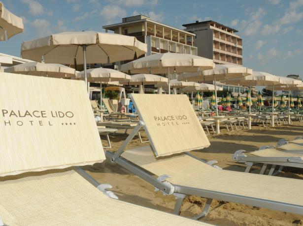 Plage aménagée de l'hôtel Palace Lido avec transats et parasols.