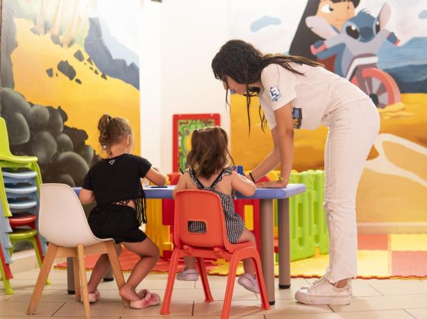 Enseignant aide les enfants à colorier en classe colorée.