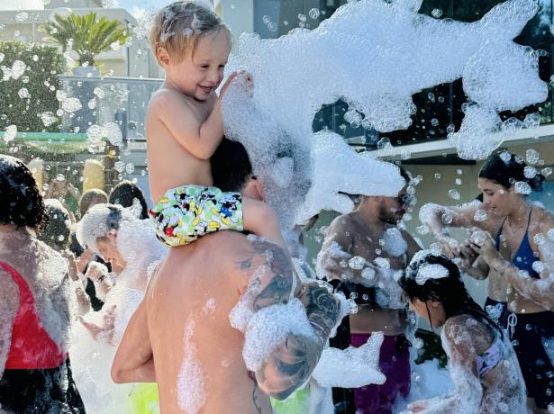 Children playing at an outdoor foam party.